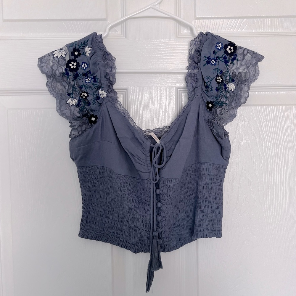 Free People periwinkle top with lace embroidered sleeves and tie/button closure